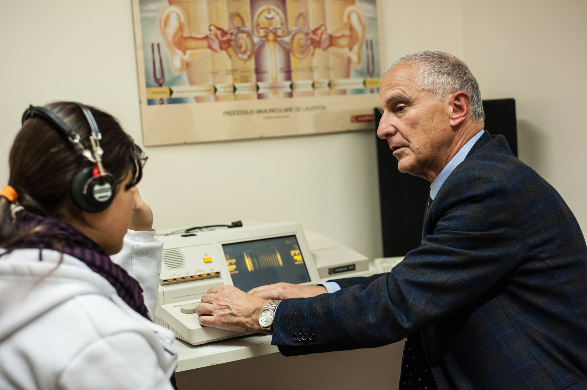 Il dott. Brozzi sta visitando una paziente utilizzando una particolare attrezzatura per la misurazione dell'udito all'interno dell'ambulatorio del Centro Nazionale