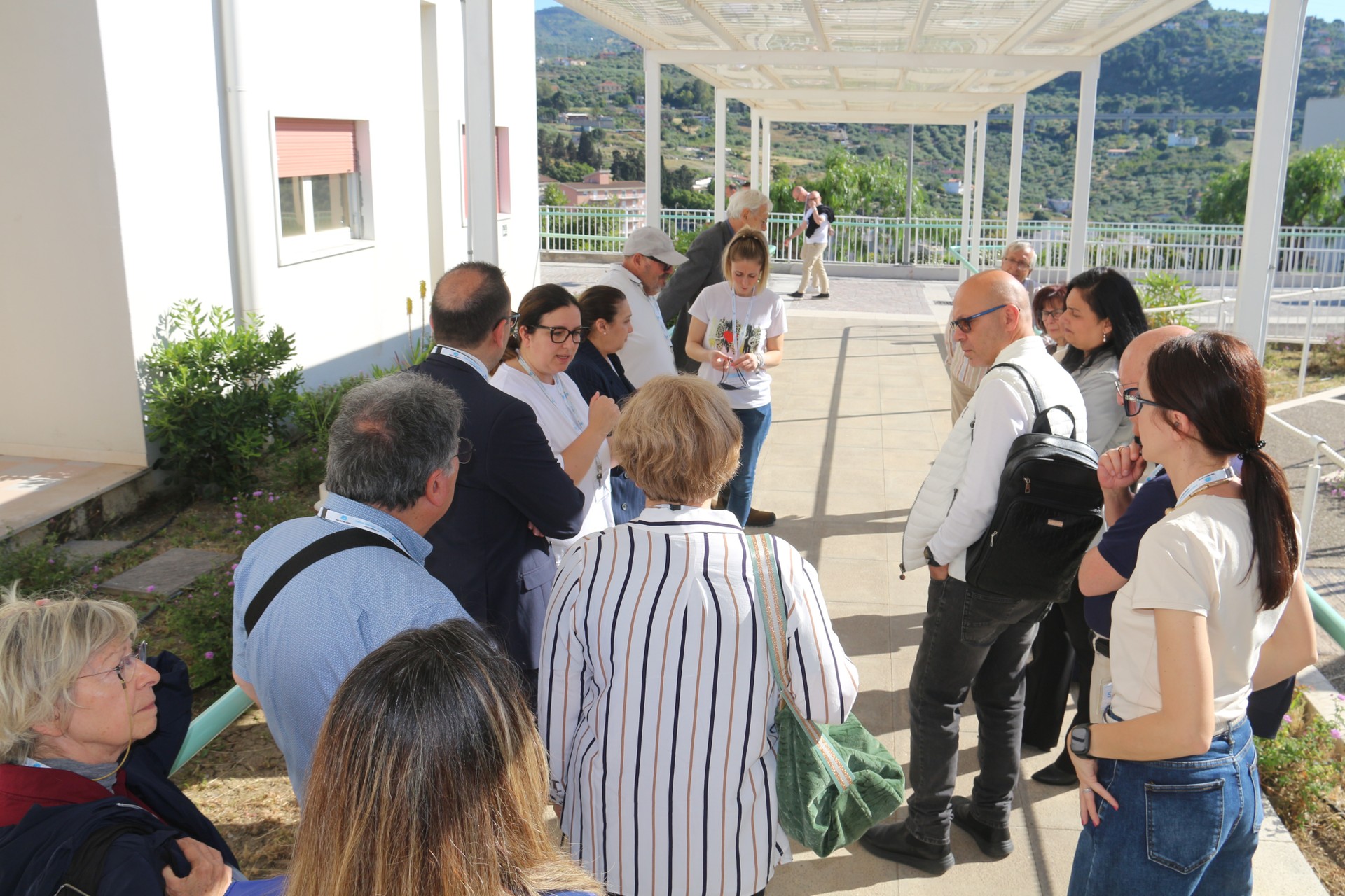 Alcuni donatori sono all'esterno di uno dei nostri Centri. Sono tutti all'ascolto della spiegazione di un membro dello staff della Lega del Filo d'Oro