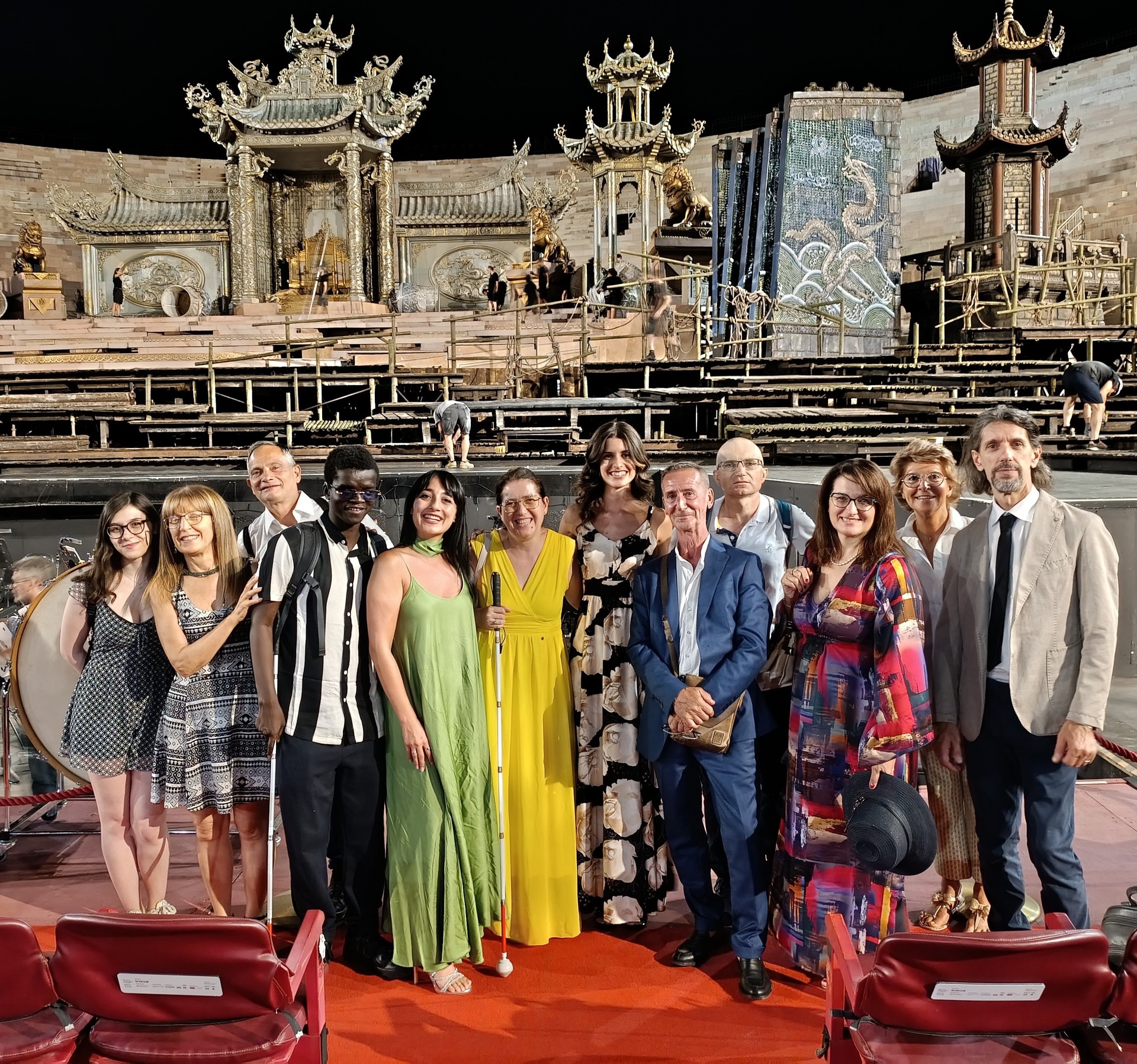 Un gruppo di utenti e educatori della Lega del Filo d'Oro di Padova posano davanti al palco dell'Arena di Verona