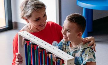 Edoardo un bambino della Lega del Filo d'Oro con un operatrice