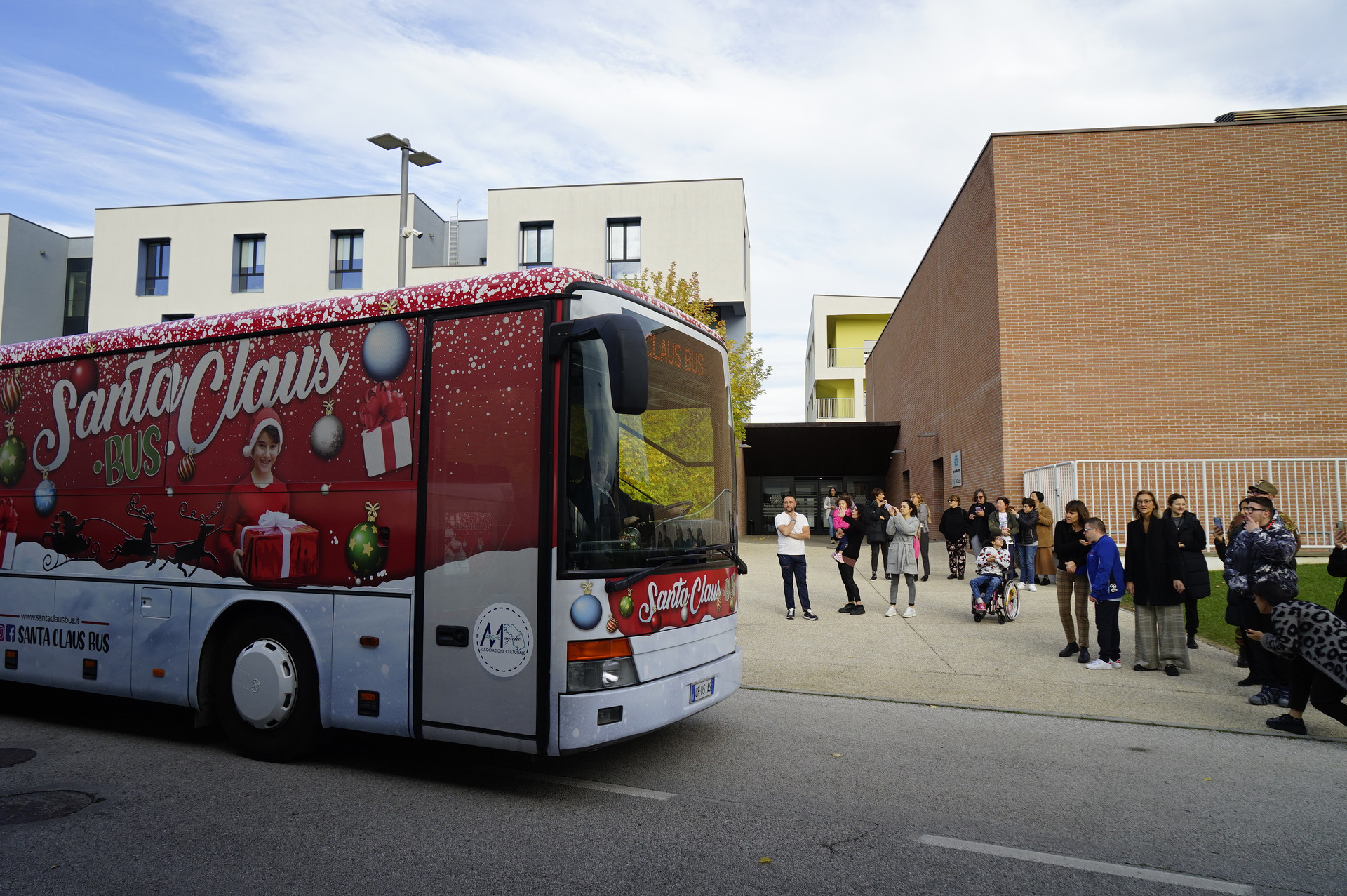 Pullman decorato per il Natale arriva all'ingresso della Lega del Filo d'Oro a Osimo, creando un'atmosfera festosa e accogliente per tutti i presenti.