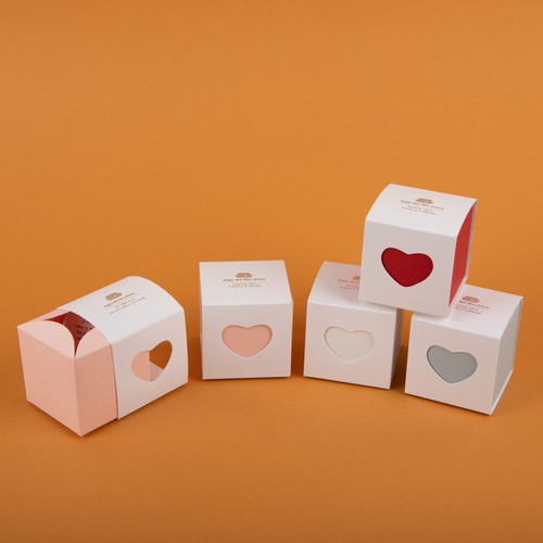 Composizione still life su sfondo arancione del pack delle bomboniere cuore 44