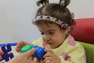 La piccola Sophie prende in mano le costruzioni che gli vengono date dalla sua educatrice