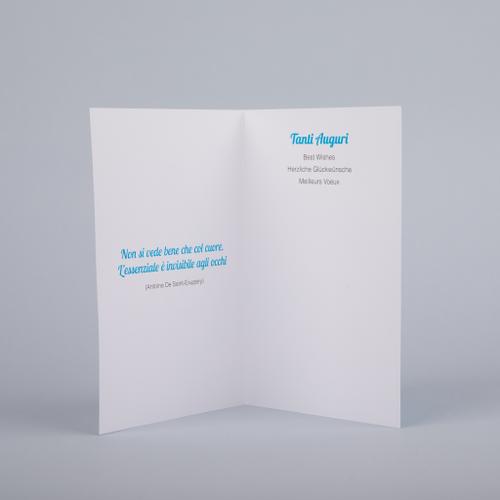 Interno del biglietto di auguri "albero azzurro". Scritta "Tanti auguri" in italiano, inglese, tedesco e francese. All'interno del biglietto è stampata la frase "Non si vede bene che col cuore. L'essenziale è invisibile agli occhi". 3