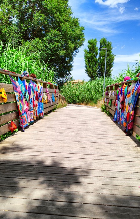 Un ponte decorato con lo yarn bombing a Osimo con tasselli multicolori realizzati a uncinetto