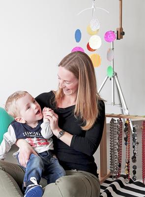 Un bambino utente della Lega della Filo d'Oro, in braccio ad un educatrice, mentre sorride