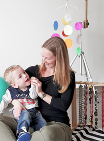 Un bambino utente della Lega della Filo d'Oro, in braccio ad un educatrice, mentre sorride