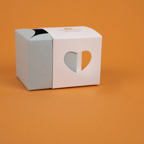 Still life su sfondo arancione del pack della bomboniera cuore celeste 48