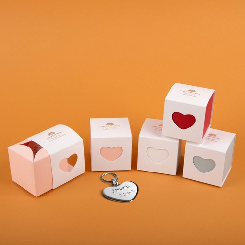 Bomboniere Cuore con Portachiavi cuore su sfondo arancione. I colori delle bomboniere sono rosa, bianco, rosso, celeste 36