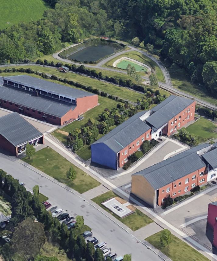 Foto aerea del Centro Residenziale di Lesmo, circondato da ampie aree verdi. L'immagine mostra quattro dei 6 edifici di cui il centro è composto. 