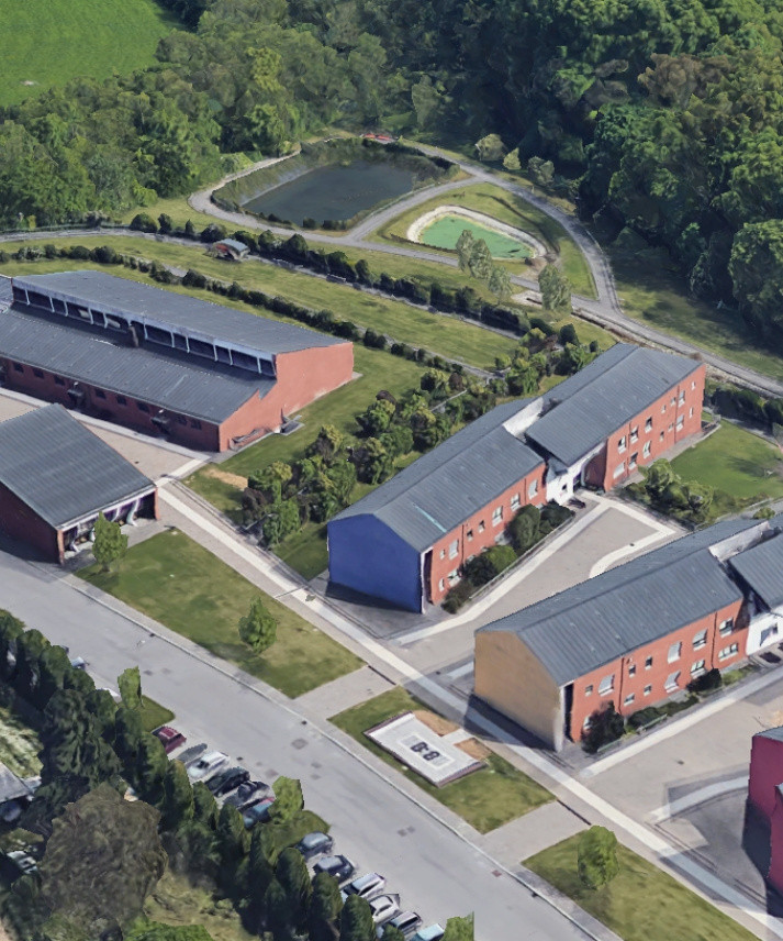 Foto aerea del Centro Residenziale di Lesmo, circondato da ampie aree verdi. L'immagine mostra quattro dei 6 edifici di cui il centro è composto. 