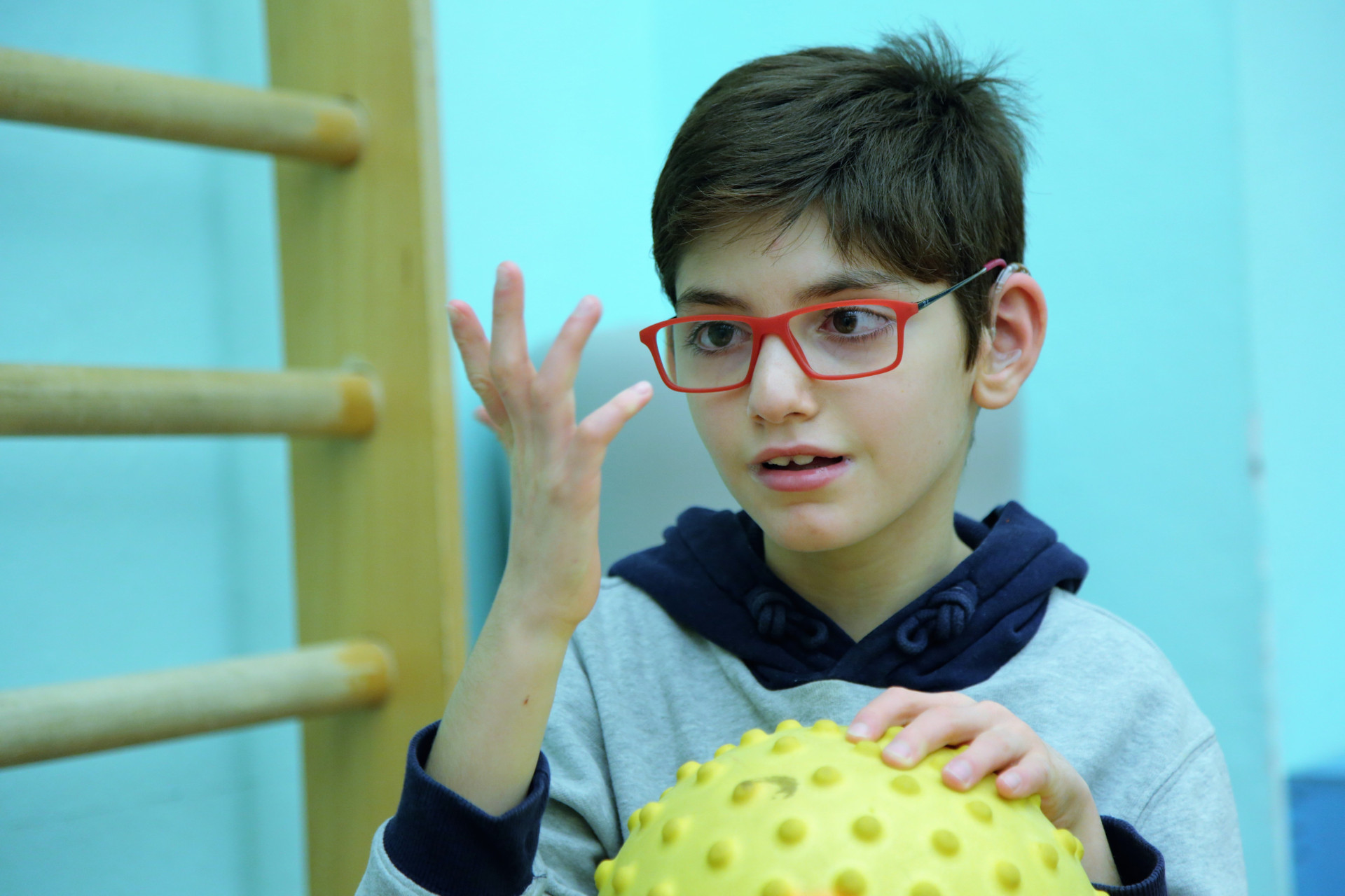 Federico, piccolo utente del Centro di Osimo, con una palla in mano durante l'attività di fisioterapia