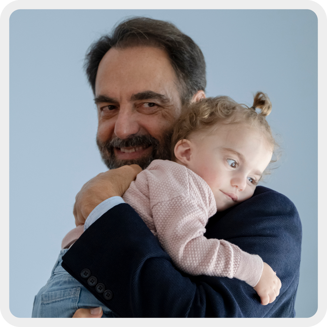 Immagine di copertina del primo capitolo del Bilancio Sociale 2024: Neri Marcorè sorride. In braccio a lui c'è Benedetta, bambina seguita dal Centro Diagnostico della Lega del Filo d'Oro con Sindrome Charge.