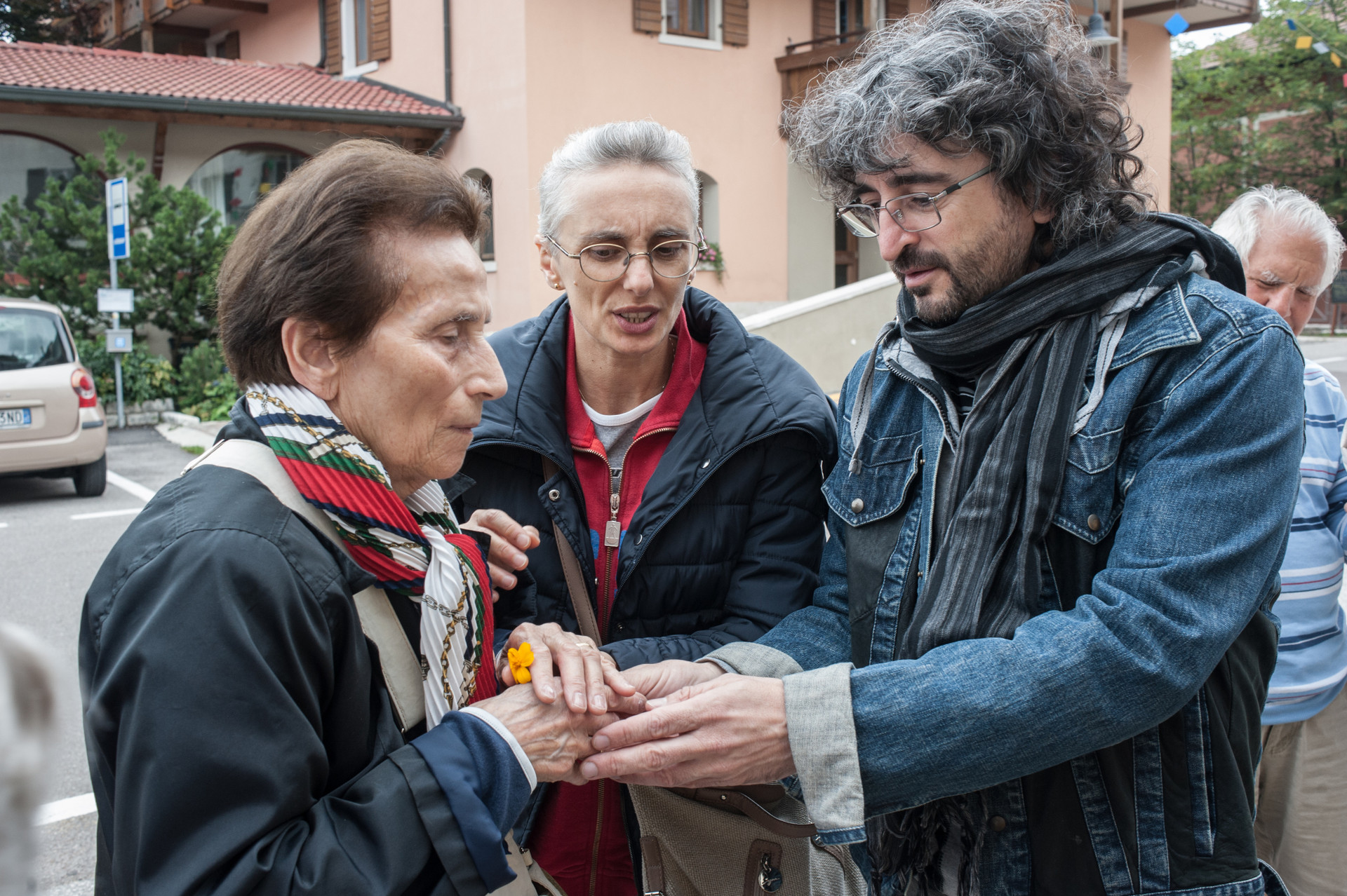 Una anziana utente con un volontario, il volontario le tocca le mani 