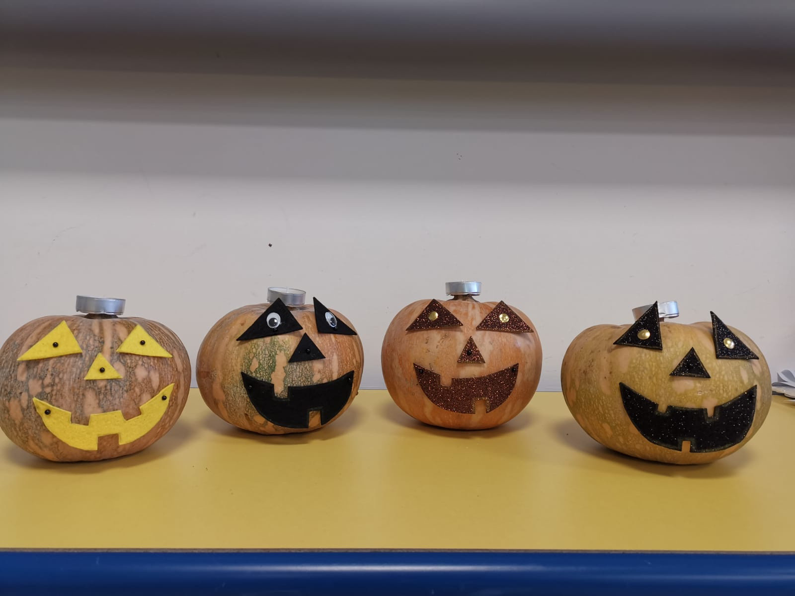 Quattro zucche decorate a tema Halloween con bocca e occhi.