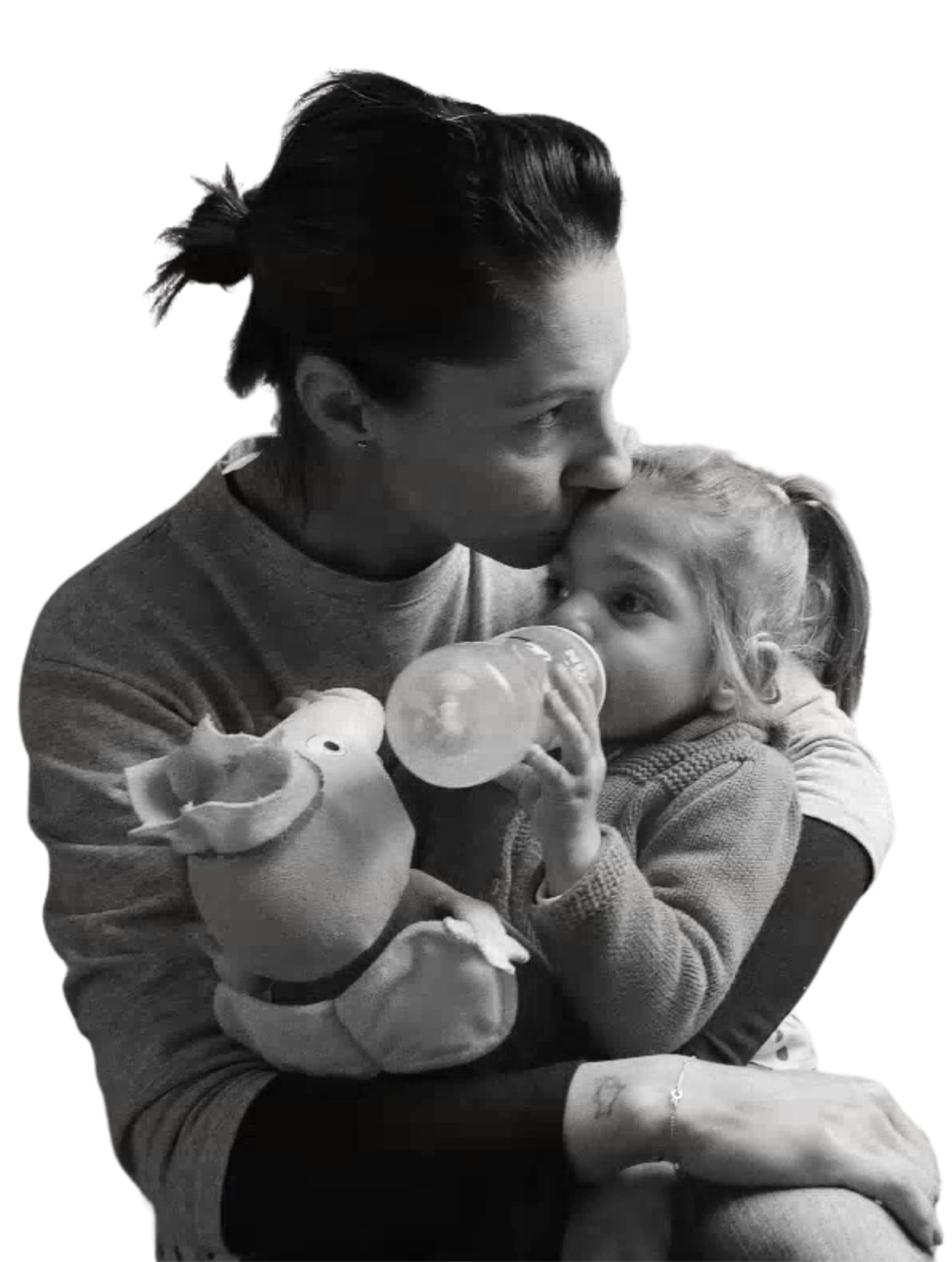 Foto in bianco e nero di Sveva che beve dal biberon in braccio alla mamma, che le dà un bacio sulla fronte