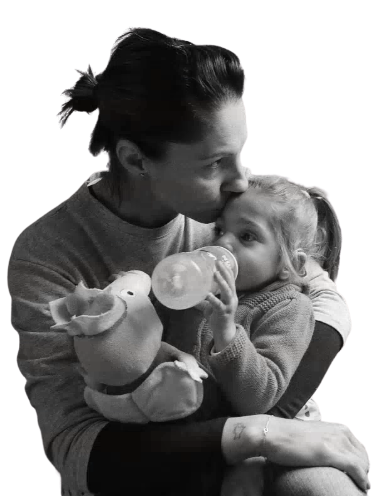 Foto in bianco e nero di Sveva che beve dal biberon in braccio alla mamma, che le dà un bacio sulla fronte