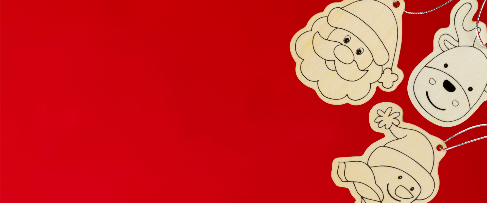 Foto su sfondo rosso di tre decorazioni natalizie in legno della Lega del Filo d'Oro, uno dei prodotti solidali ordinabili sul sito