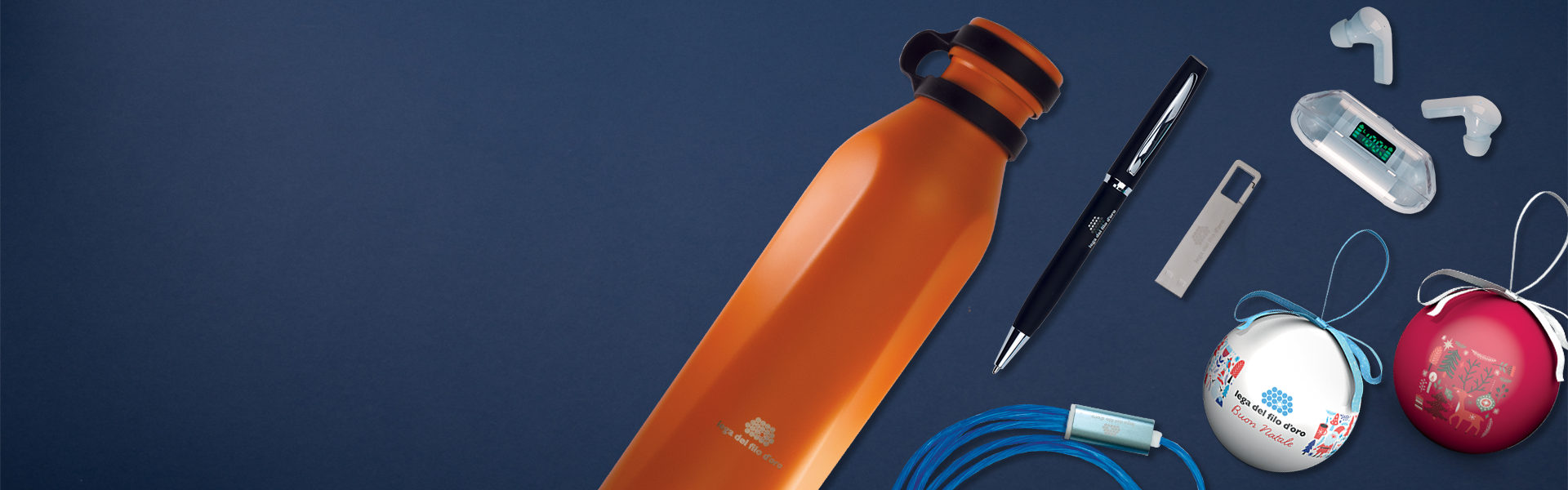 Composizione di prodotti dello shop su sfondo blu scuro, con in evidenza una penna, una borraccia termica arancione, auricolari , USB e due palline natalizie, una di colore bianco e una di colre rosso.