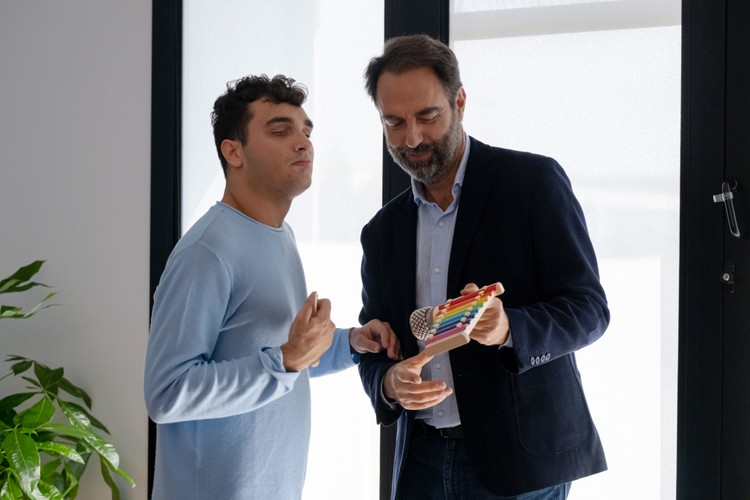 Neri Marcorè ha in mano uno xilofono e lo porge a Francesco