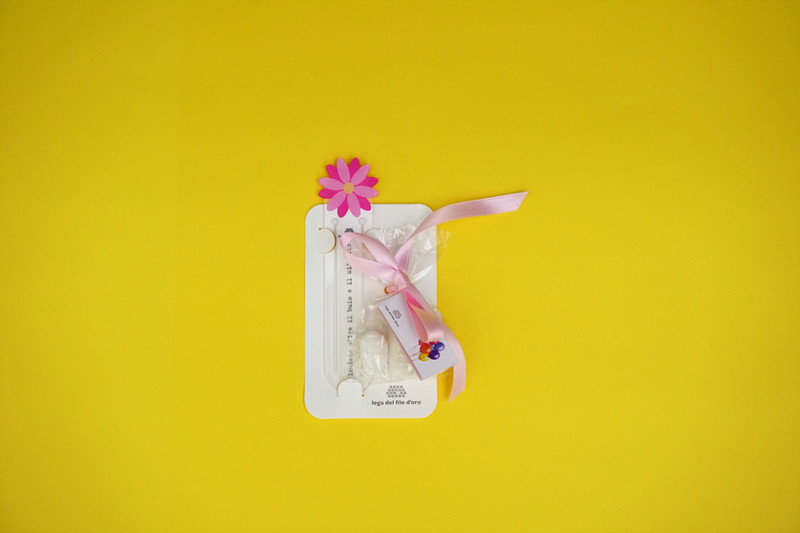 Bomboniera solidale segnalibro fiore Lega del Filo d'Oro per celebrare con solidarietà il battesimo, la nascita, la comunione.