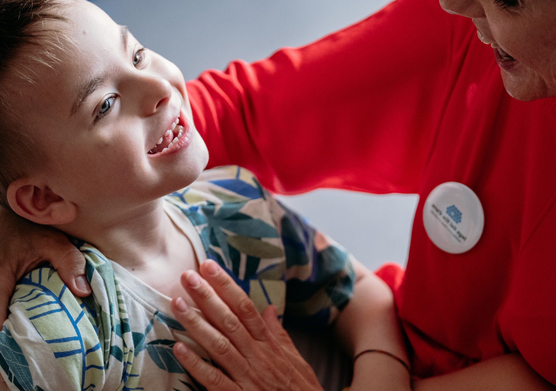 Edoardo in braccio alla sua educatrice giocano e sorridono