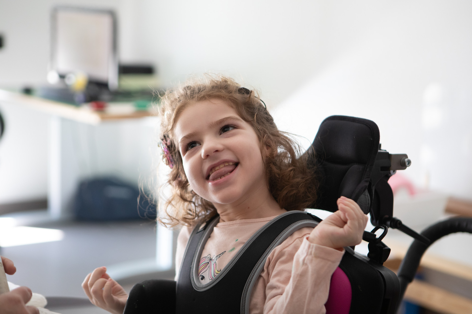 Bambina con disabilità visiva, uditiva e motoria che sorride