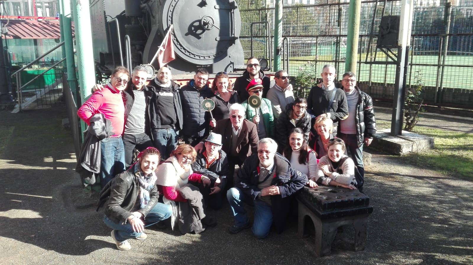 Utenti in visita ai treni a vapore a Napoli. Foto di gruppo davanti la locomotiva di un treno storico. 