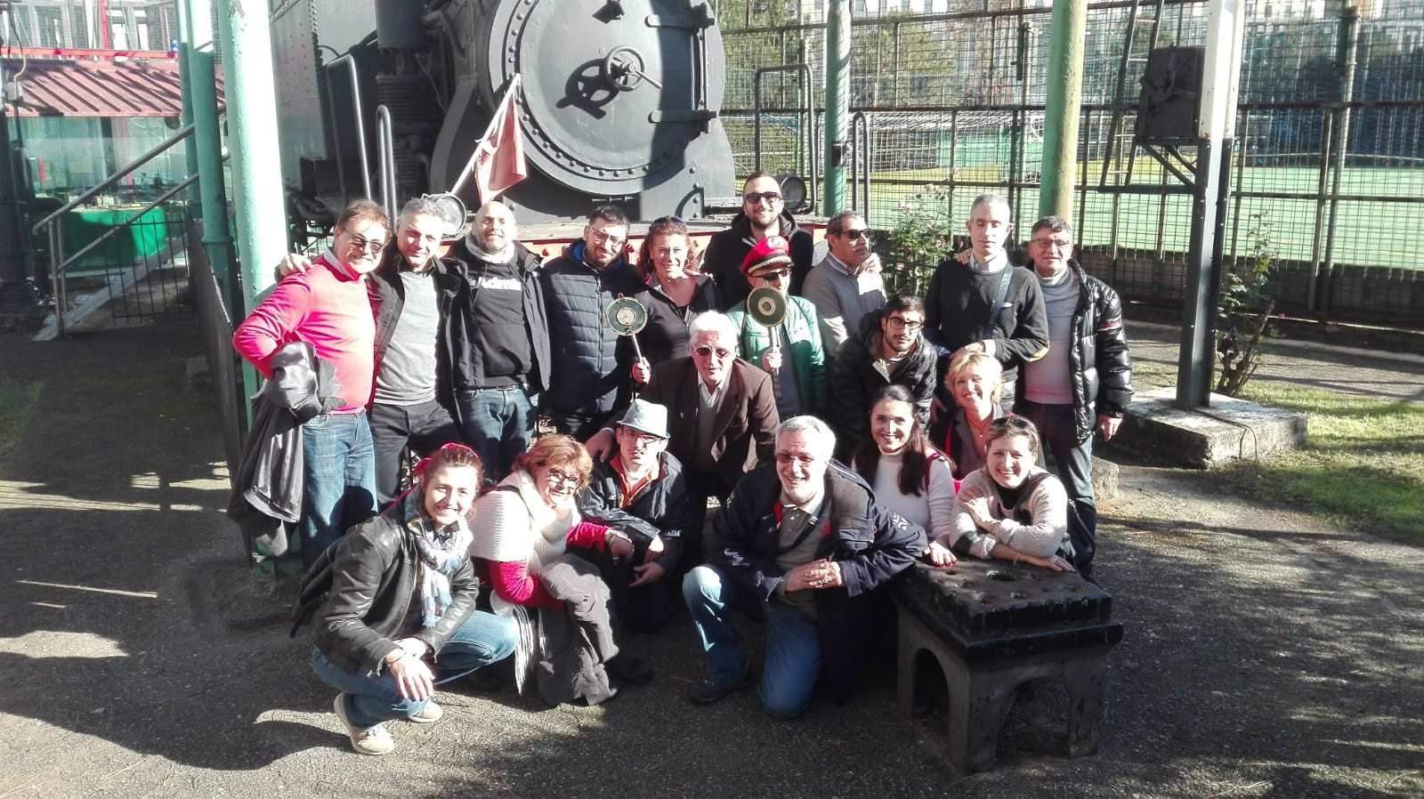 Utenti in visita ai treni a vapore a Napoli. Foto di gruppo davanti la locomotiva di un treno storico. 