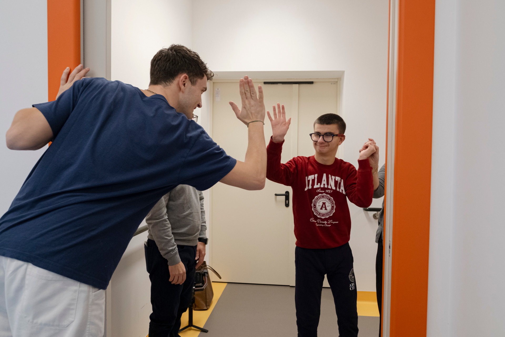 Luigi, finita l'ora di Fisioterapia, saluta il suo Fisioterapista con un "batti cinque" sorridendo