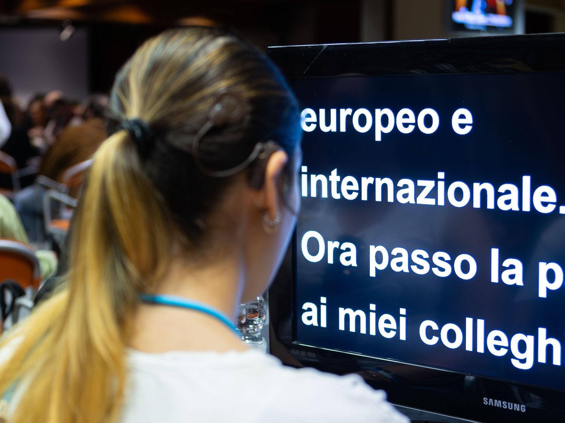 Lucia, utente seguita dal Servizio Territoriale della Lega del Filo d'Oro, partecipa attraverso un video ingranditore con una sottotitolazione in tempo reale di quanto viene detto dai relatori