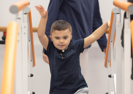 Leonardo, un bambino affetto della sindrome di Charge, sta svolgendo attivitò di fisioterapia con Francesca, fisioterapista del Centro di Osimo della Lega del Filo d'Oro. Leonardo sta salendo delle scale 