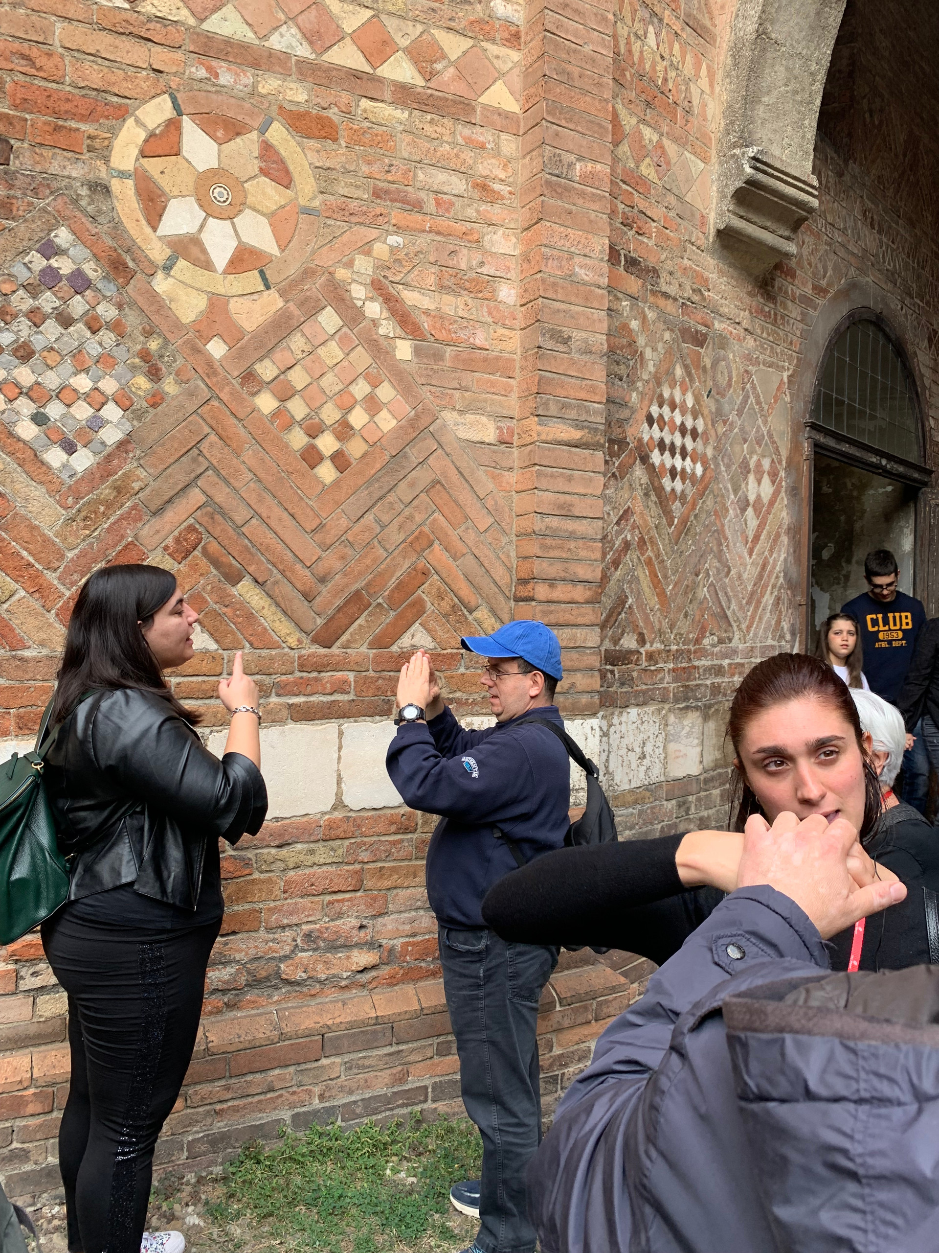 All’interno di un chiostro, utenti e volontari comunicano utilizzando la LIS o la LIST.