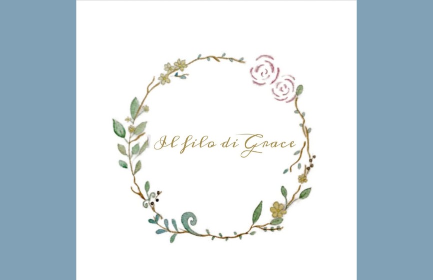 logo con la scritta "Il filo di Grace" in un font corsivo dorato, circondato da una ghirlanda acquerellata di foglie verdi e piccoli fiori rosa e gialli, su uno sfondo bianco.
