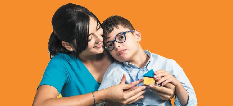 Un bambino utente della Lega del Filo d'Oro che gioca con delle costruzioni di legno.