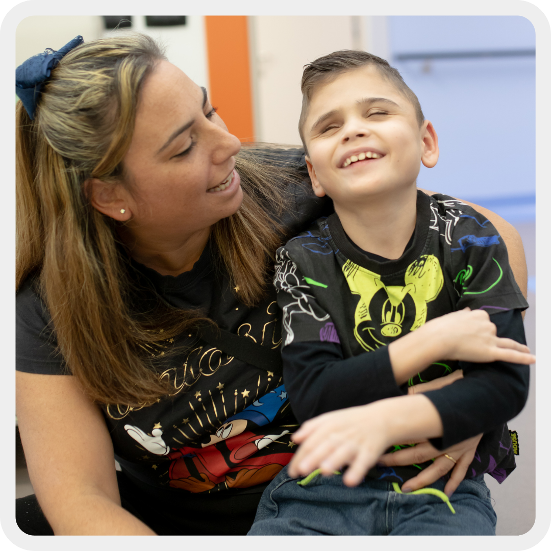 Emanuela, mamma di Matteo, bambino seguito dalla Sede Territoriale di Napoli, tiente in braccio il suo bambino che ridono insieme.