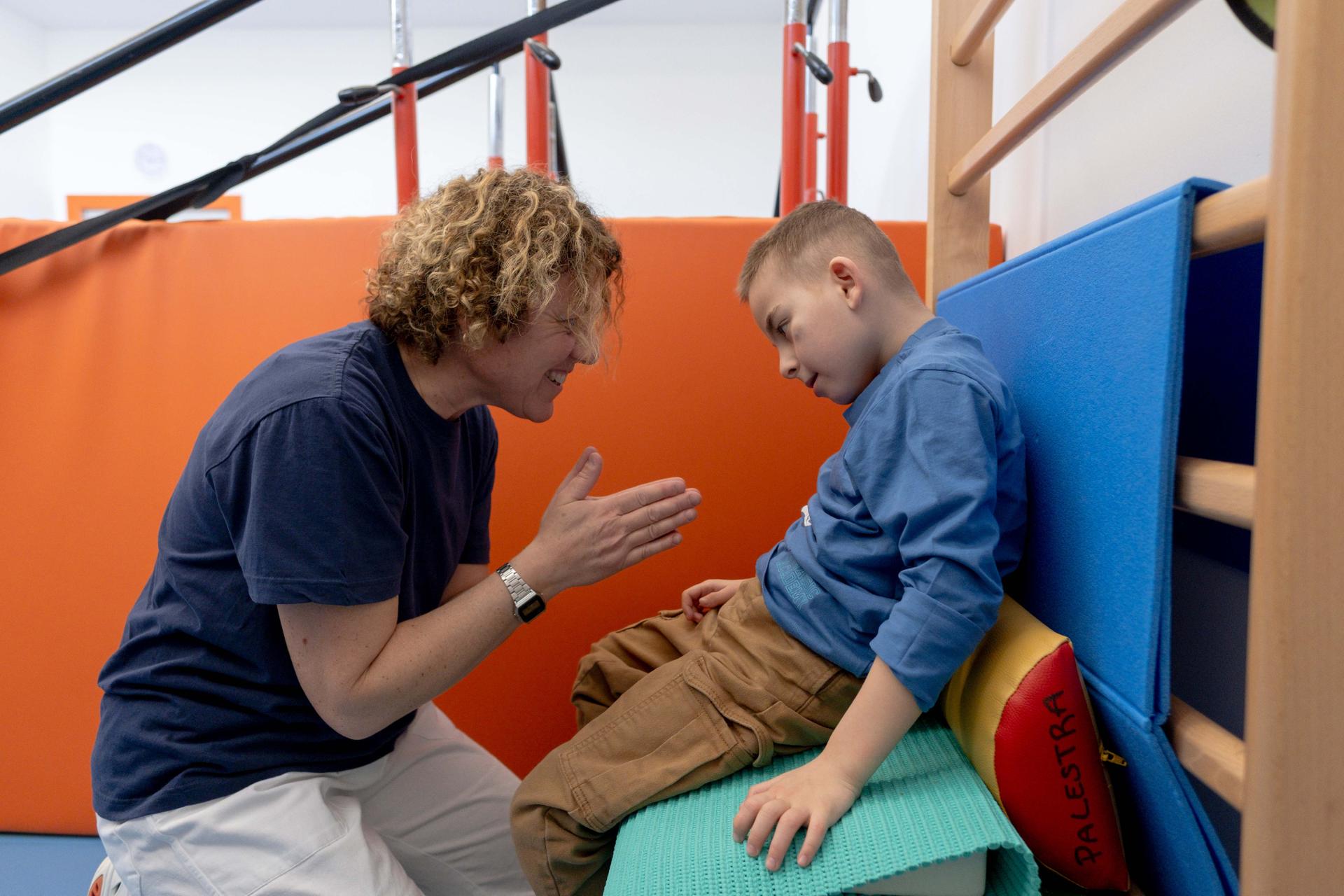 La fisioterapista Raffaella ed Edoardo sono ritratti insieme durante una sessione di fisioterapia all'interna di una delle palestre presso il Centro Nazionale della Fondazione Lega del Filo d'Oro di Osimo. 