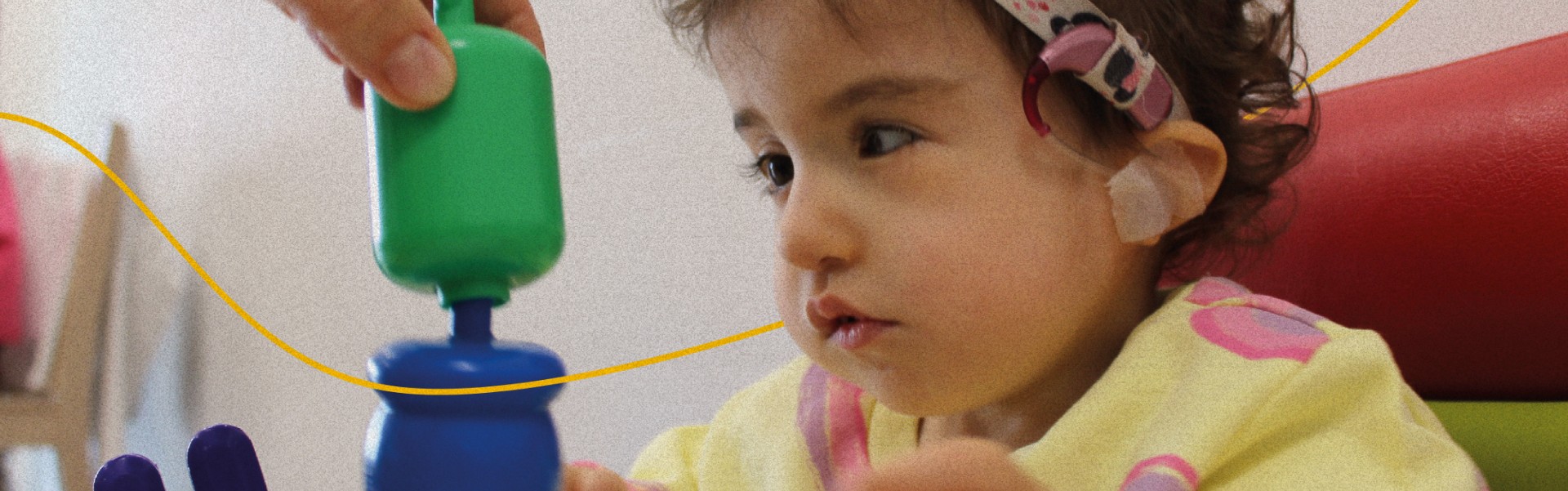 Sophie, bambina della Lega del Filo d’Oro, sorride in primo piano. 