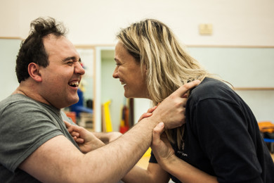 Alberto, un utente della Lega del Filo d'Oro, e Francesca la fisioterapista ridono di gusto insieme.