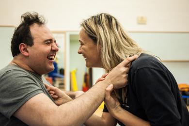 Alberto, un utente della Lega del Filo d'Oro, e un'operatrice ridono di gusto insieme.