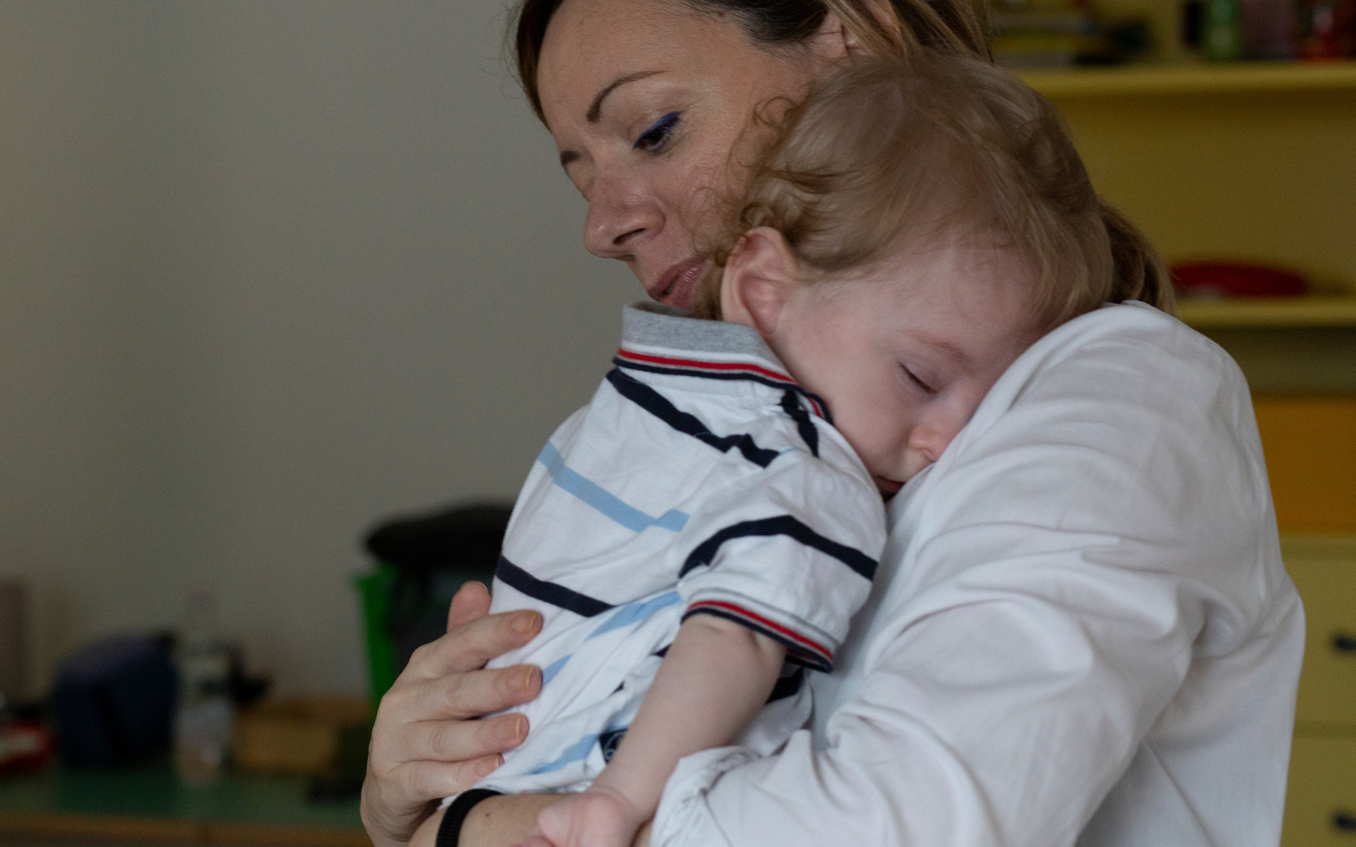 Il piccolo Gabriele, bambino utente del Centro di Osimo, dorme in braccio alla mamma