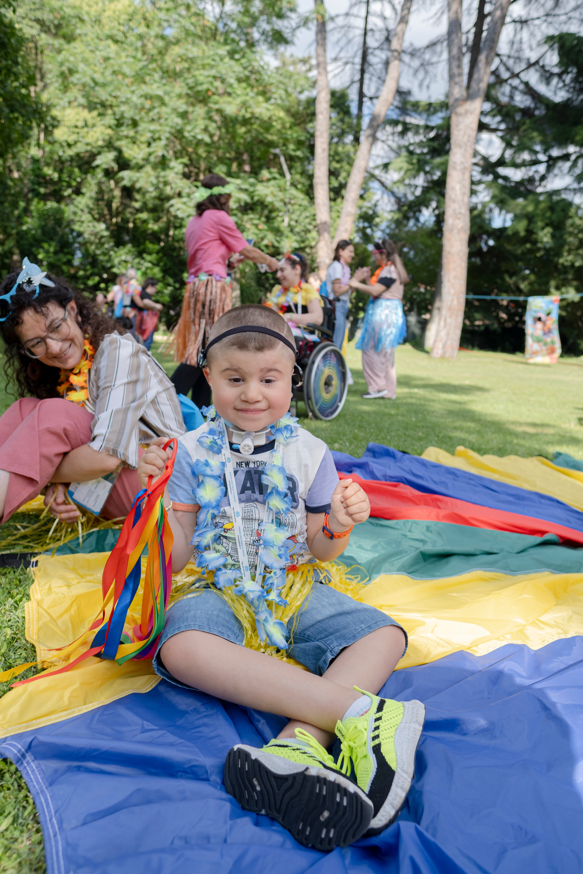 Berkay, bambino seguito dalla Lega del Filo d'Oro con sindrome Charge, ripreso mentre gioca in giardino su tappetoni colorati all'Assemblea delle Famiglie ad Assisi