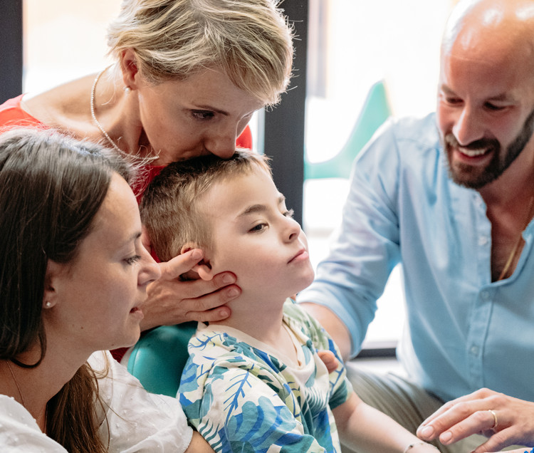 Edoardo insieme a mamma Caterina, papà Giovanni e Manola, una delle educatrici che lo segue nel suo percorso educativo-riabilitativo