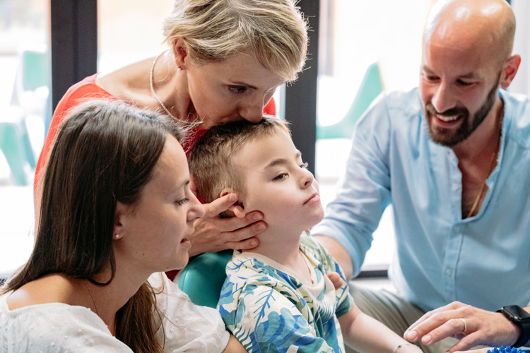 Edoardo insieme a mamma Caterina, papà Giovanni e Manola, una delle educatrici che lo segue nel suo percorso educativo-riabilitativo