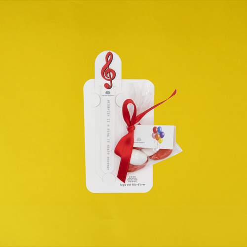 Still life su sfondo giallo della bomboniera chiave di violino rossa 13