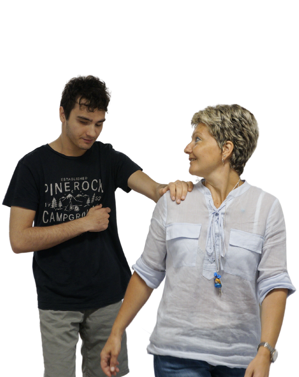 Francesco, un nostro utente, cammina accompagnato dalla sua educatrice tenendole una mano sulla spalla.