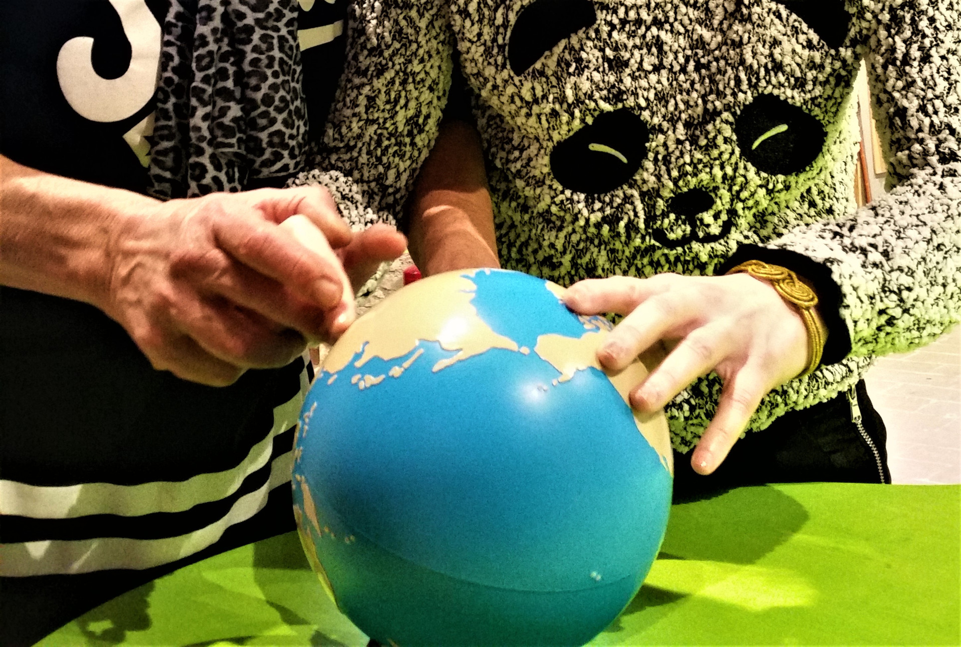 Due persone toccano un mappamondo.