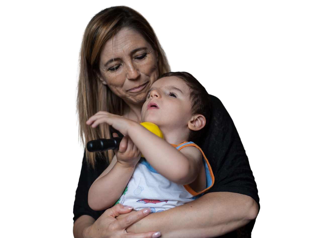 Mamma Antonella tiene in braccio Nicolò (bambino seguito dalla Lega del Filo d'Oro). Lo guarda con un sorriso di tenerezza.