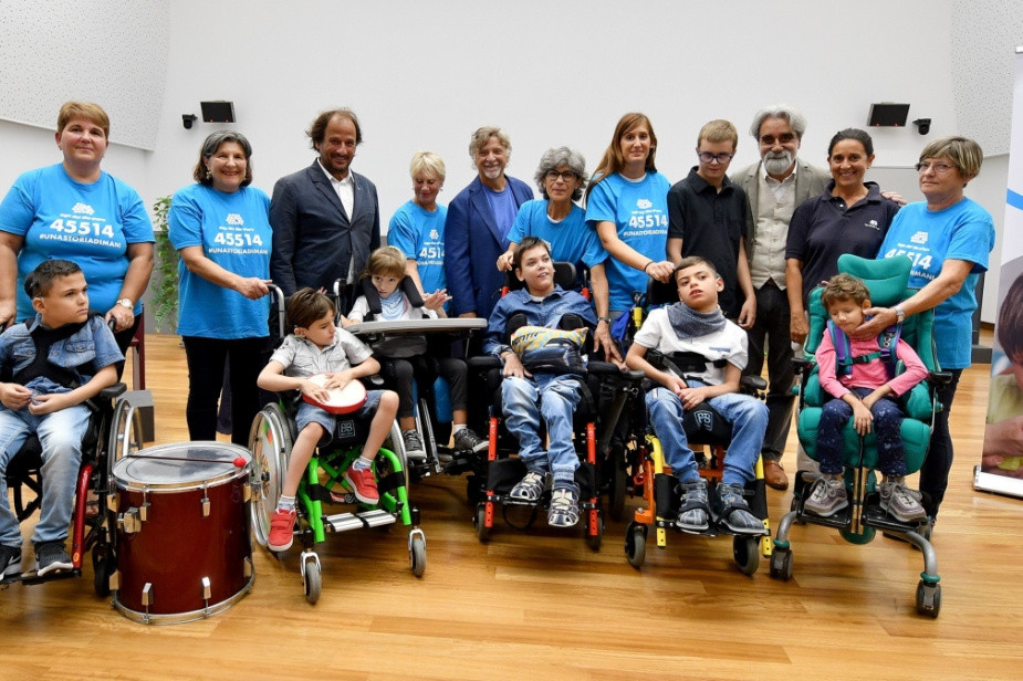 Foto di gruppo di utenti e operatori che indossano la maglia della Lega del filo d'Oro con riportato il numero 45514 per donare con messaggio