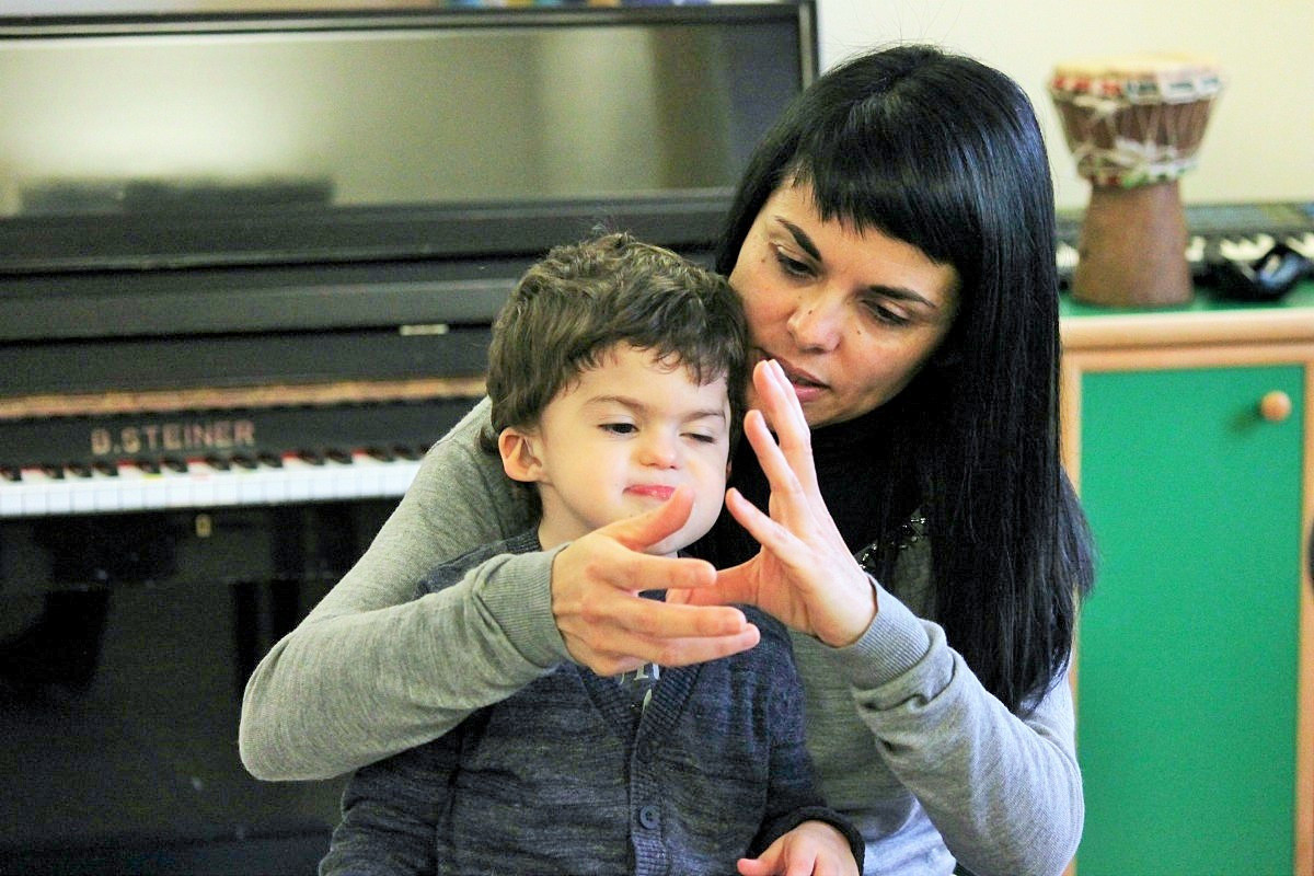 Mamma Simona tiene in braccio Agostino e gli "canta" una filastrocca aiutandosi con la LIS